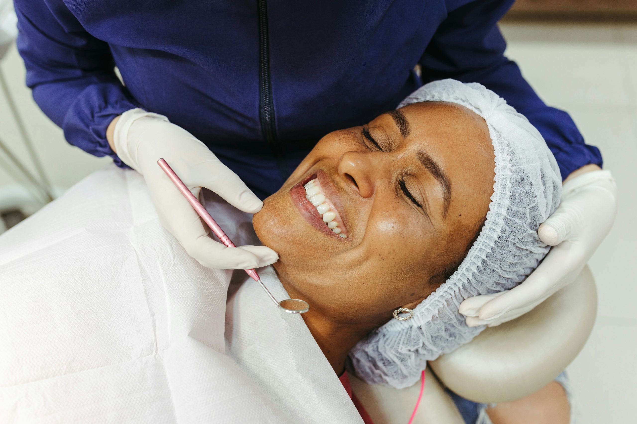 Dental professional smiling in front of dental equipment.