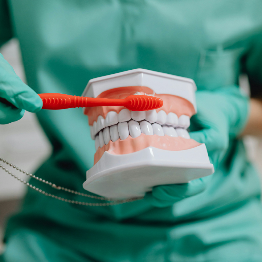 Dental professional smiling in front of dental equipment.