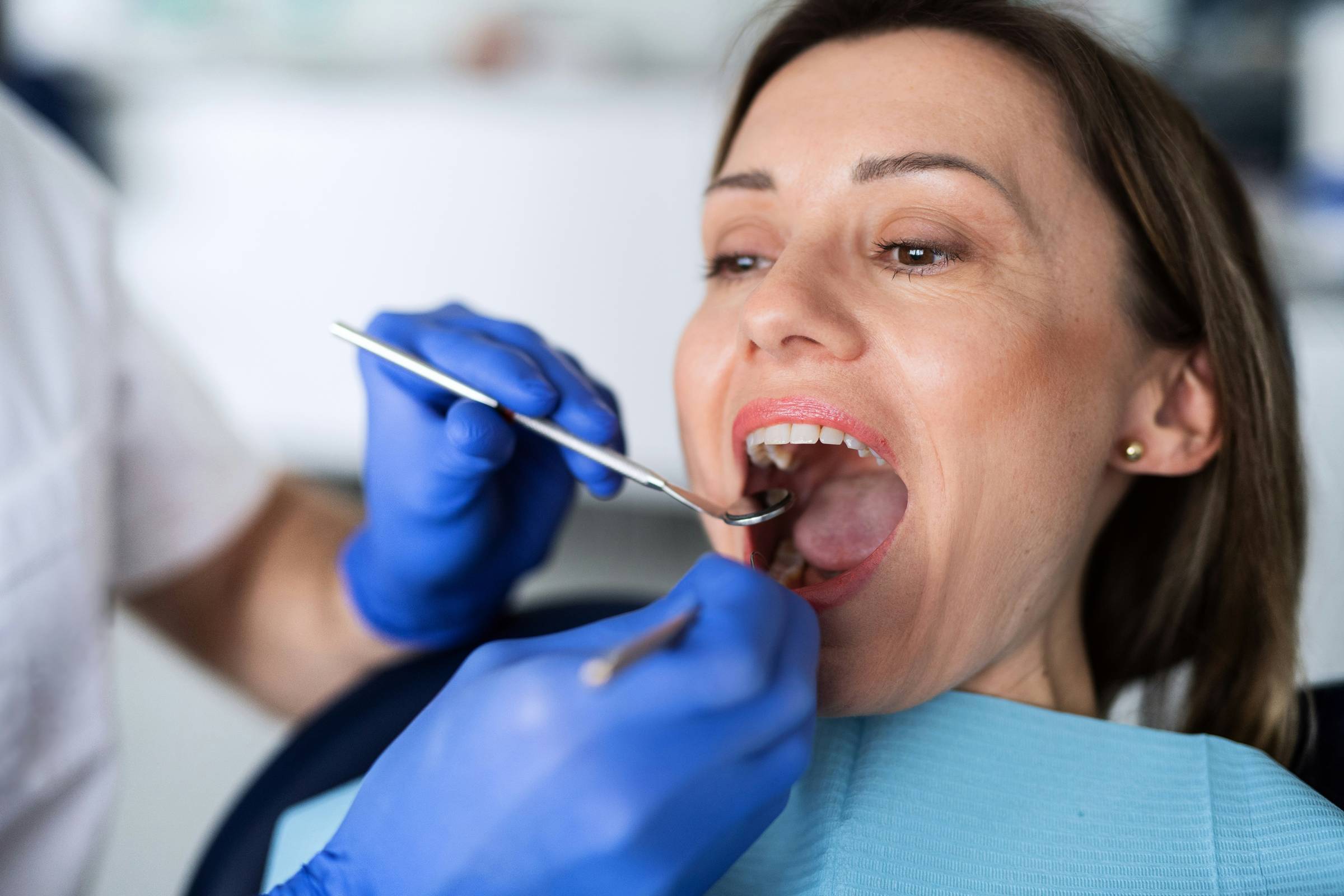 Dental professional smiling in front of dental equipment.