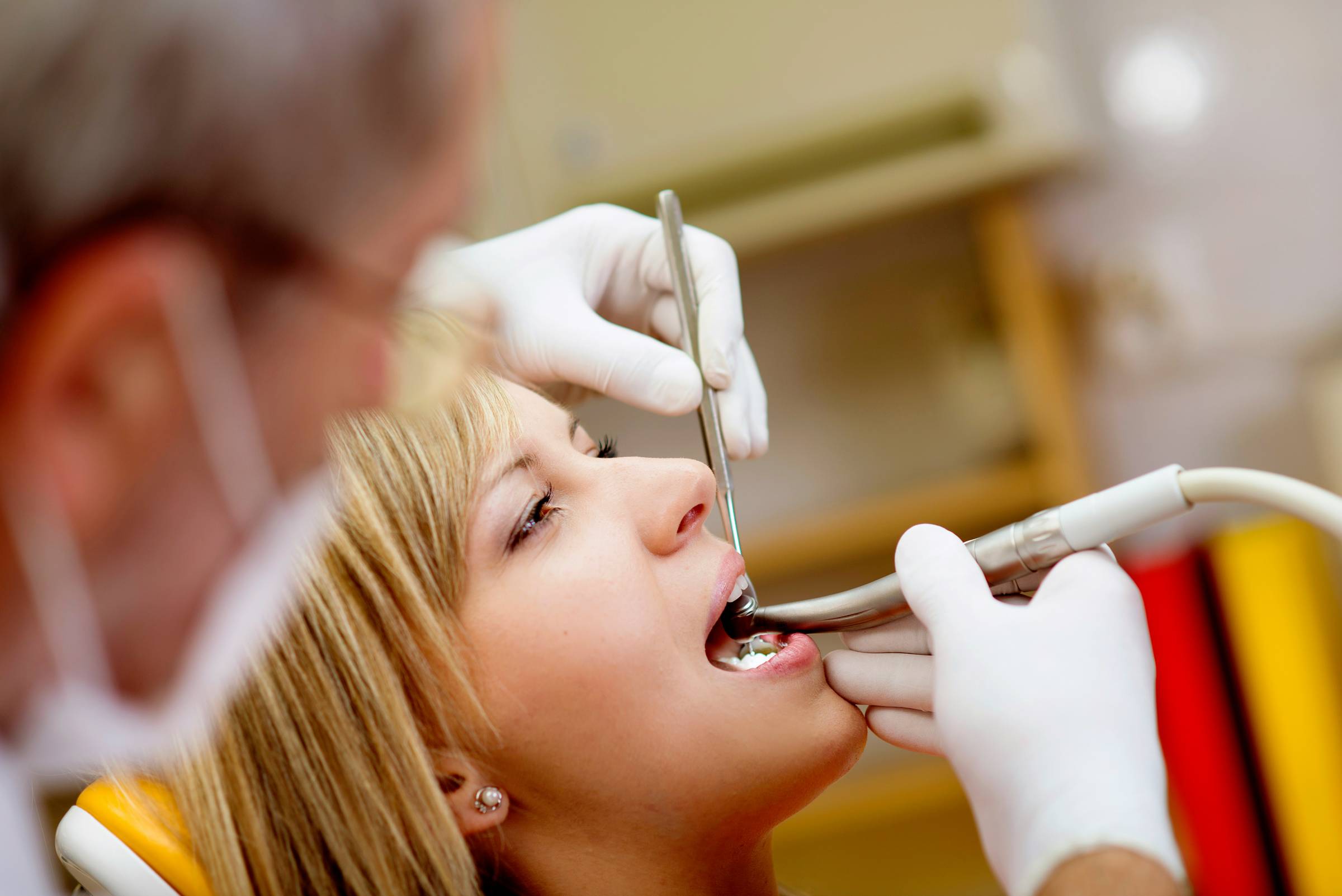 Dental professional smiling in front of dental equipment.