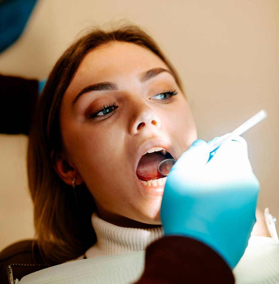 Dental professional smiling in front of dental equipment.