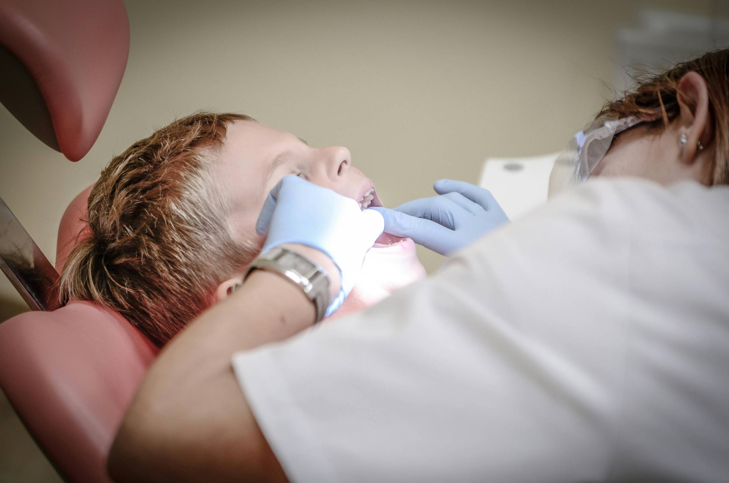 Dental professional smiling in front of dental equipment.